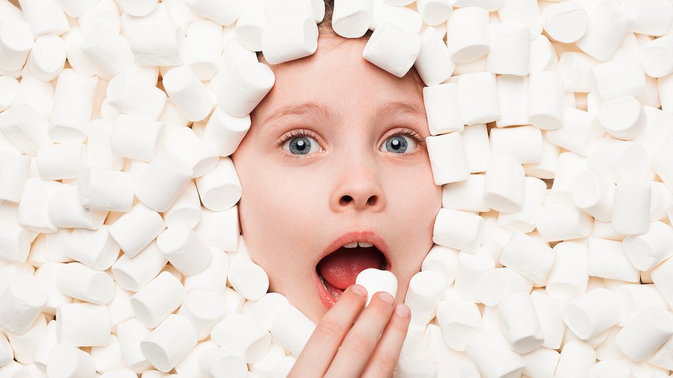 Niña comiéndose un marshmellow