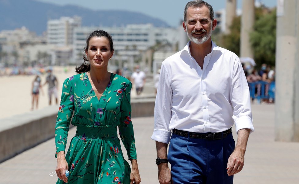 Королева Летиция (слева) и король Испании Фелипе VI (справа) приветствуют туристов, прогуливающихся по набережной Эль-Ареналь в Пальма-де-Майорка, Испания, 25 июня 2020 г.