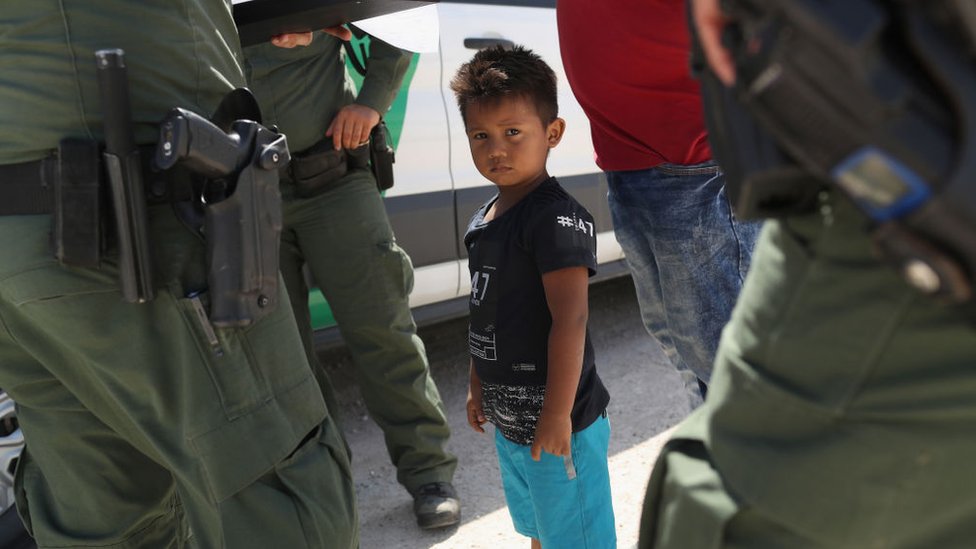 Un niño migrante, rodeado de agentes de la Patrulla Fronteriza.