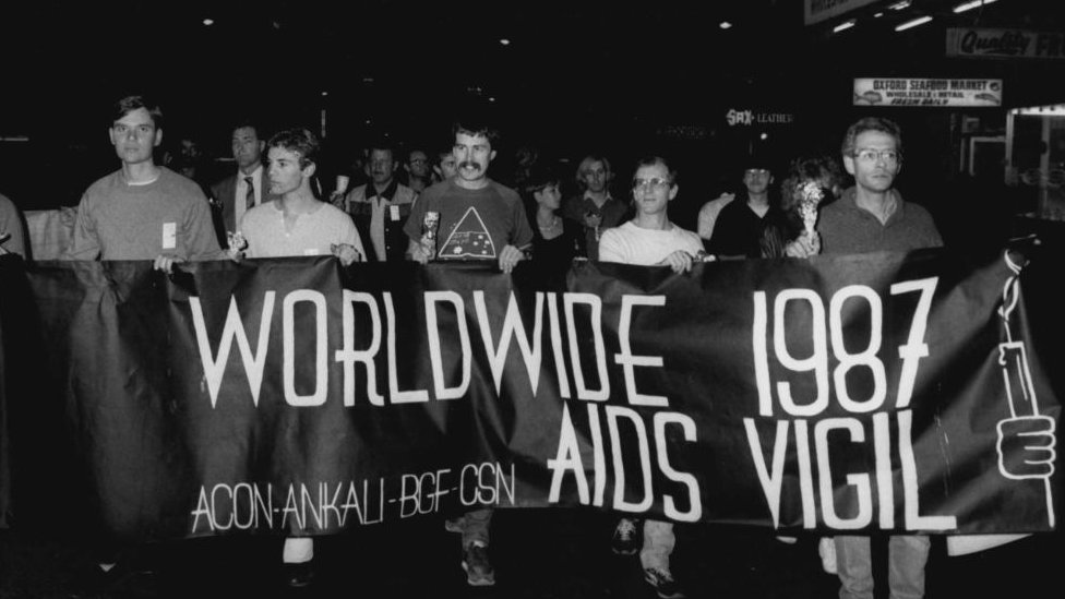 Cinco hombres marchando contra el sida en una calle en Sídney en los 80.