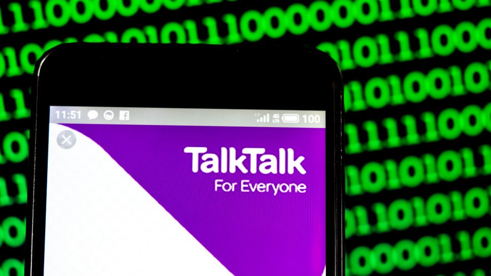 Логотип TalkTalk здесь показан на телефоне на фоне зеленого двоичного кода на фотографии