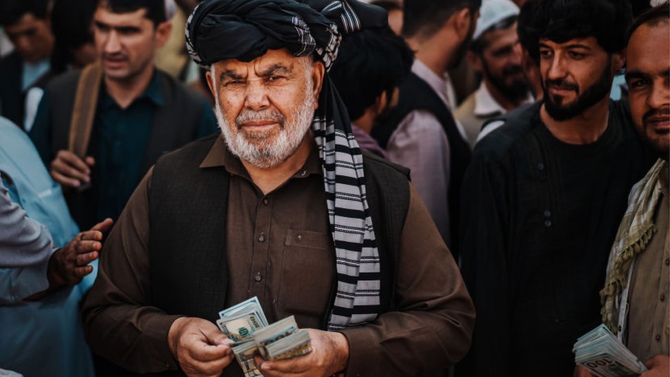 Un cambista ofrece dólares en un mercado de Kabul.