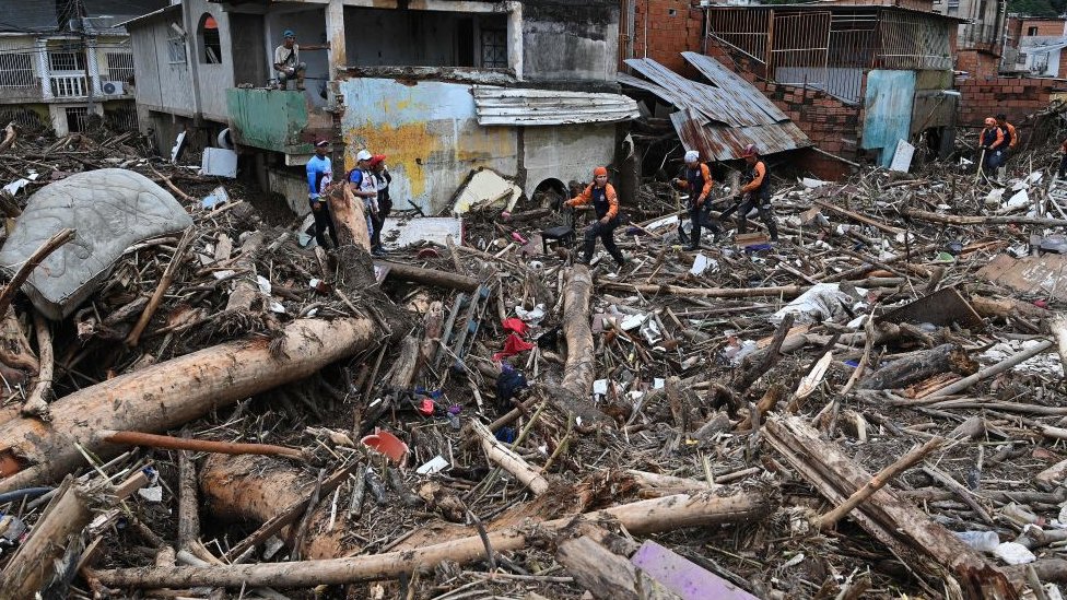Rescatistas y residentes buscan entre los escombros de casas destruidas víctimas o sobrevivientes de un deslizamiento de tierra durante fuertes lluvias en Las Tejerias, estado de Aragua, Venezuela, el 9 de octubre de 2022.