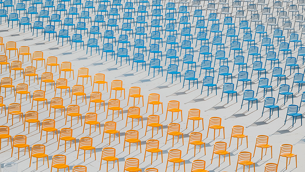 Filas de sillas vacías de colores brillantes desiertas en una escuela