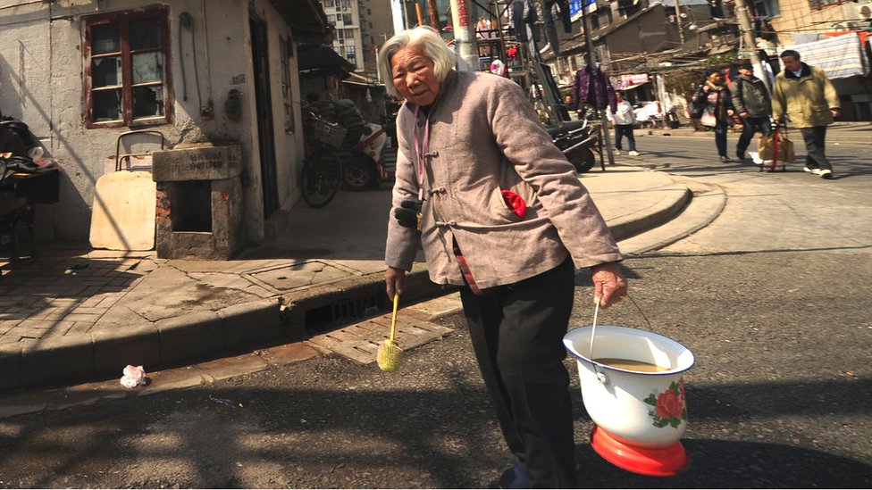 An elderly lady heads to the communal toilet in a poor neighbourhood of Shanghai on 6 March 2013 - Xi Jinping was elected president on 14 March 2013