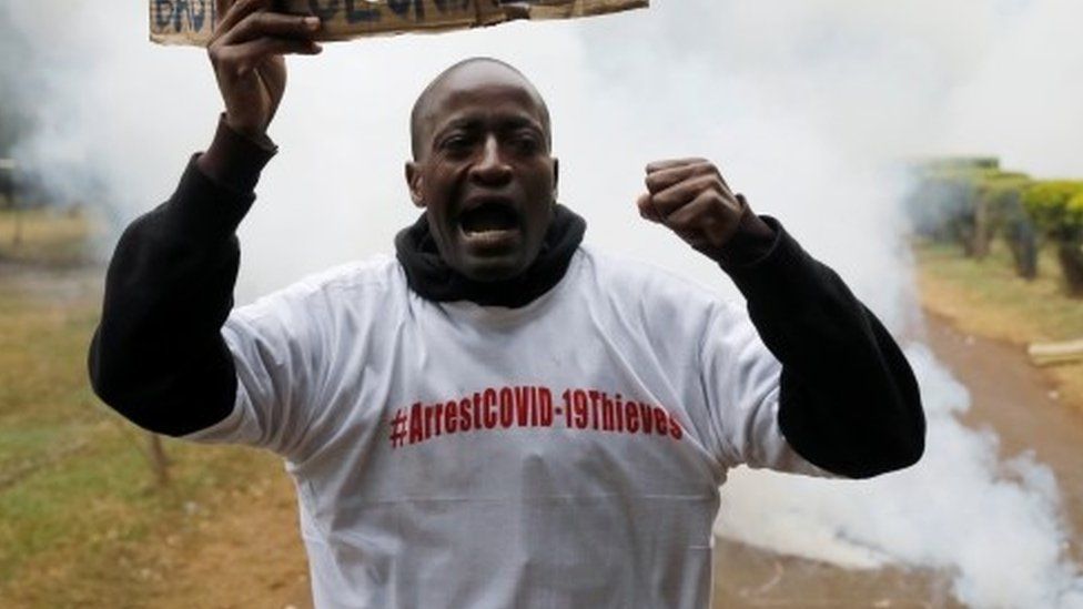 Протестующий держит плакат, охваченный слезоточивым газом во время демонстрации против предполагаемой коррупции в ответ правительства Кении на вспышку коронавирусной болезни (COVID-19) в Найроби, Кения, 21 августа 2020 г.