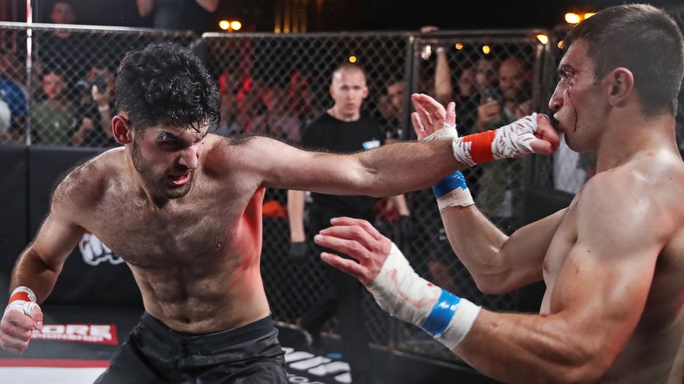 Emil Bakhshiyev (L) and Mukhamed Kalmykov compete in a bout during the Round of 16 of the Hardcore Fighting Championship