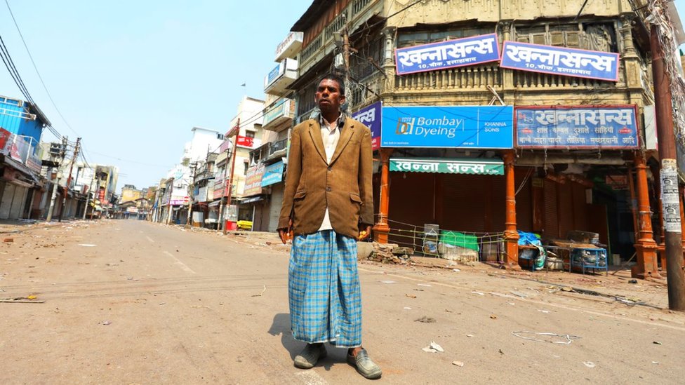 Kishan Lal stands in an empty street the northern Indian city of Allahabad,