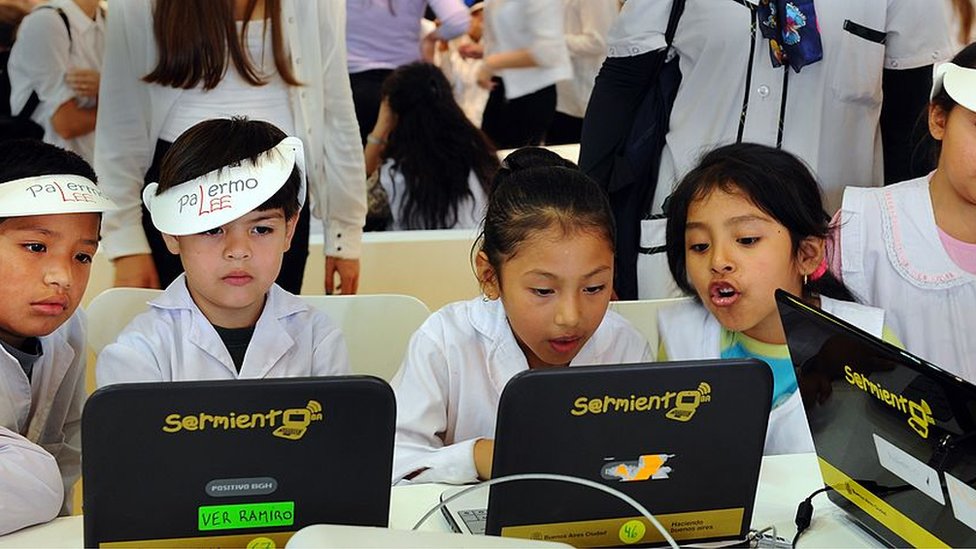 La falta de inversión en infraestructura y tecnología es parte del problema. Niños frente a computadores en Argentina