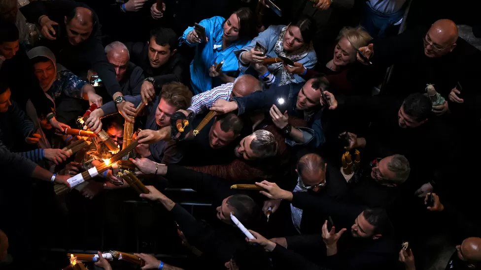 مسيحيون أورثوذكس يشعلون شموعهم في أثناء الاحتفال بالنار المقدسة يوم سبت النور