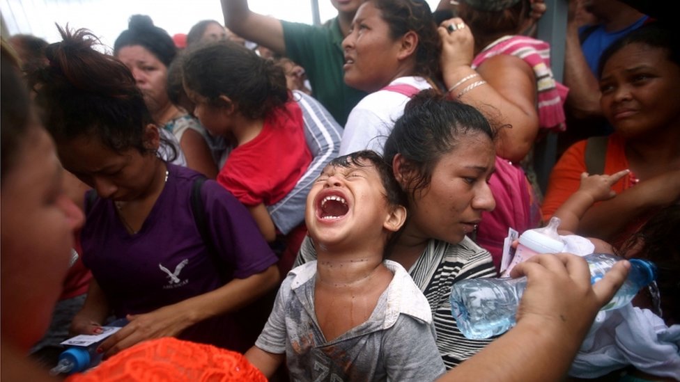 Niño llora en medio de la multitud en la frontera entre Guatemala y México.