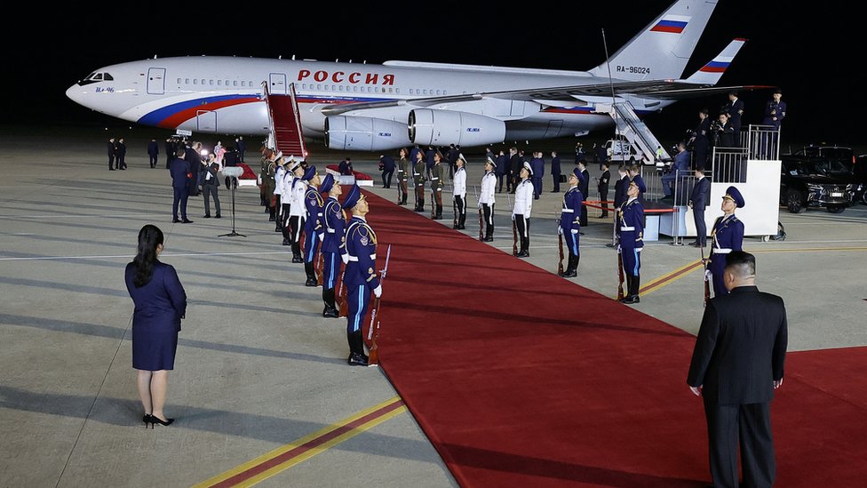 In this pool photograph distributed by the Russian state agency Sputnik, North Korea's leader Kim Jong Un (R) awaits Russian President Vladimir Putin on the tarmac during a welcoming ceremony upon Putin's arrival at Pyongyang Airport, early on June 19, 2024. Russian President Vladimir Putin landed in North Korea early on June 19, the Kremlin said, kicking off a visit set to boost defence ties between the two nuclear-armed countries as Moscow pursues its war in Ukraine. (Photo by Vladimir SMIRNOV / POOL / AFP) (Photo by VLADIMIR SMIRNOV/POOL/AFP via Getty Images)
