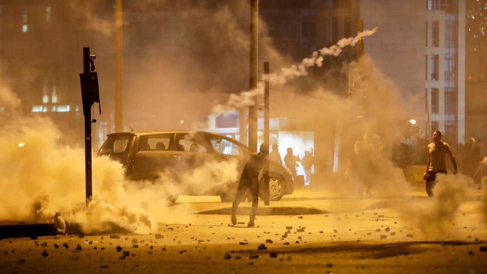 Ливанские демонстранты бросают канистры со слезоточивым газом в ОМОН во время столкновений в столице Бейруте