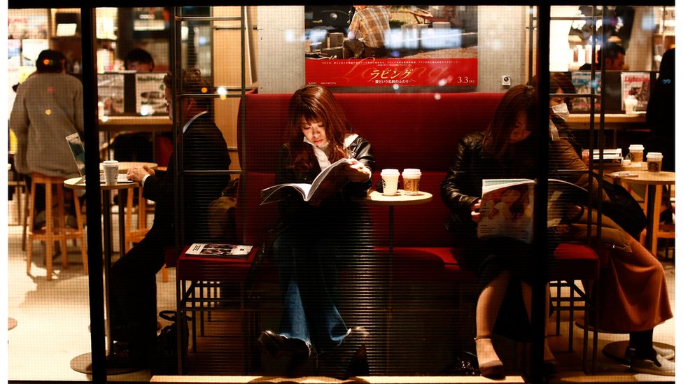 Люди читают в кафе в районе Мегуро в Токио, Япония, 8 марта 2017 года.
