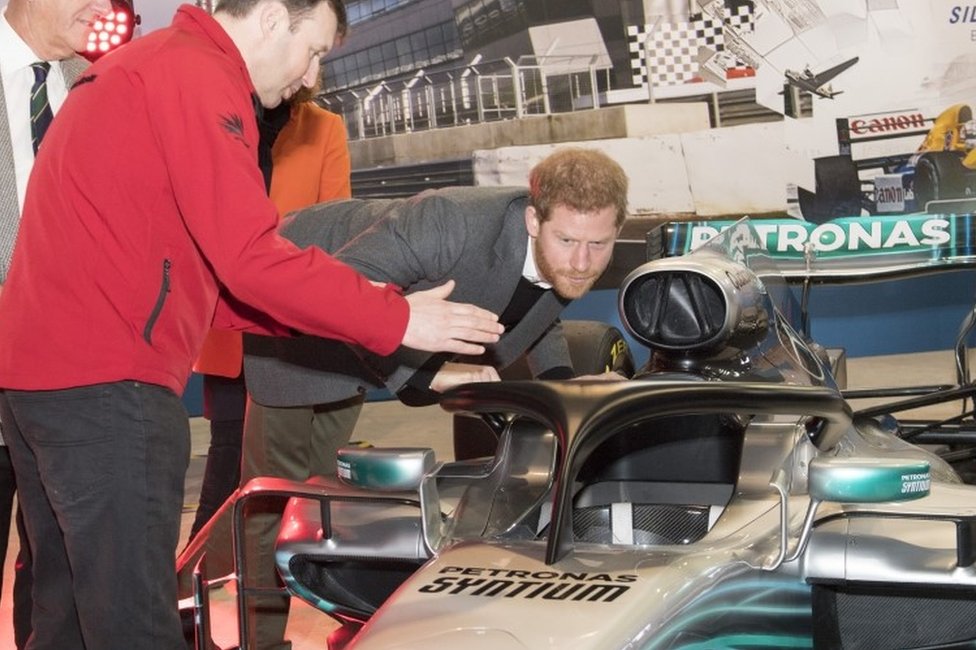 Принц Гарри изучает «Ореол» на Mercedes Льюиса Хэмилтона, новое дополнение к безопасности автомобилей Формулы 1 в этом году, во время посещения автодрома Сильверстоун в Нортгемптоншире