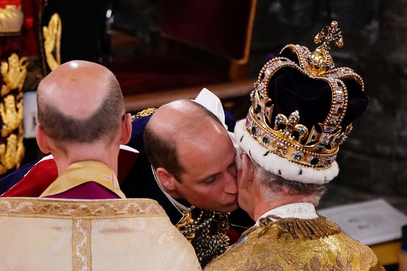 The Prince of Wales kisses his father during the King's coronation ceremony
