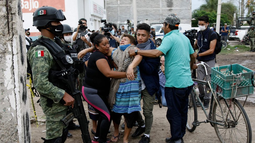 Женщина реагирует около места преступления, где погибли 24 человека, в Ирапуато, штат Гуанахуато, Мексика, 1 июля 2020 года.
