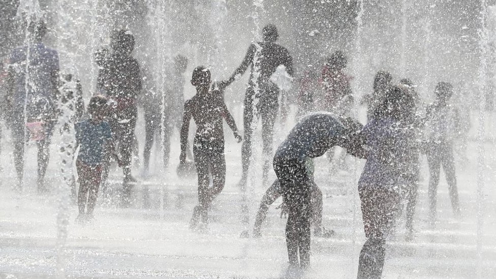 Gente refrescándose en fuentes de agua en Niza, Francia.