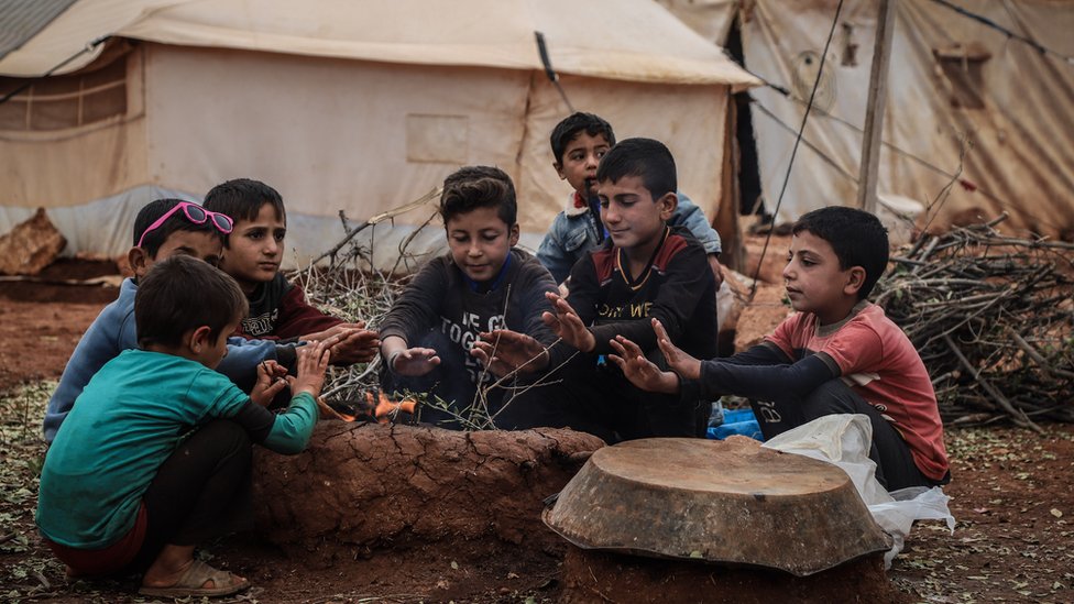 أطفال سوريون نازحون شمال سوريا أوقدوا نارا للاستدفاء بها وسط الخيام في ظل موجة برد غير مسبوقة