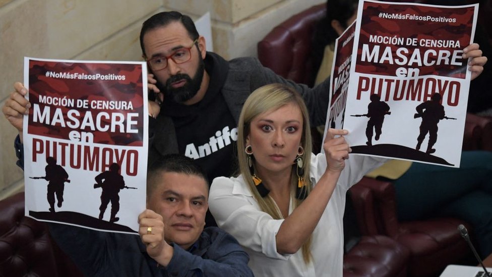 Personas sostienen carteles que llaman la atencion sobre la masacre del Putumayo