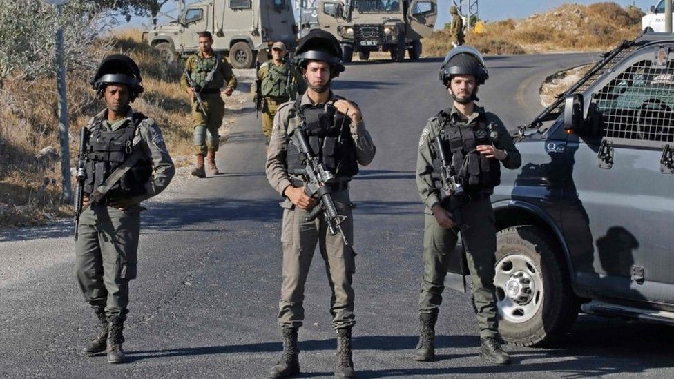 جنود إسرائيليون يقفون في مكان العثور على جثة الجندي