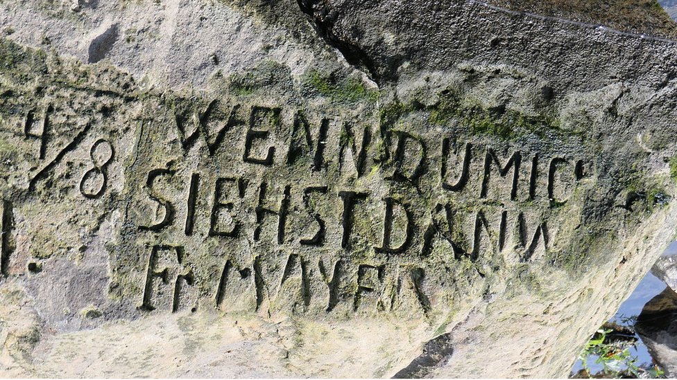 Inscripción en la piedra del hambre de Děčín: «Wenn du mich siehst, dann weine» («Si me ves, llora»).