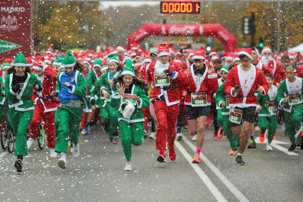 People wearing Santa Claus outfits take part in a charity race to raise funds to help vulnerable families bringing up children, in Madrid, Spain - 18 December 2022.