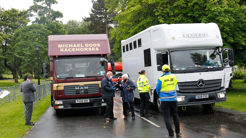 Официальные лица BHA проверяют боксы для лошадей по прибытии в Эр на первую встречу в Шотландии с момента возобновления Скачков.