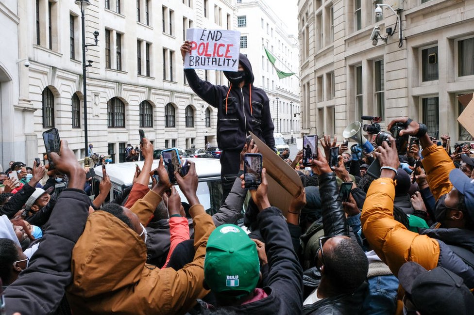 Protesters take photos of Wizkid outside the Nigeria High Commission on 11 October.