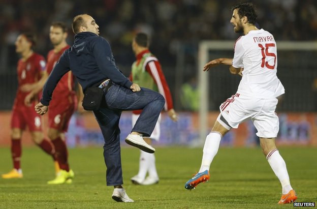 A Serbia fan confronts an Albanian player in the stadium in Belgrade, 14 October