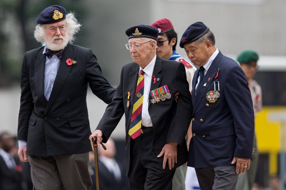 Hong Kong veterans walk after laying wreaths in front of the Cenotaph in Hong Kong, China,