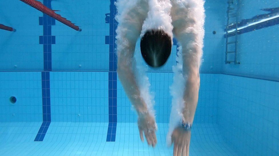 Hombre nadando en una piscina