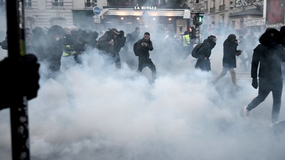 Протестующие спасаются от слезоточивого газа во время демонстрации в Париже 11 января 2020 г.
