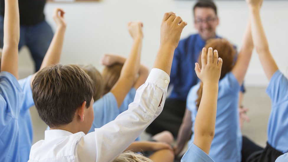 Дети с поднятыми руками в классной