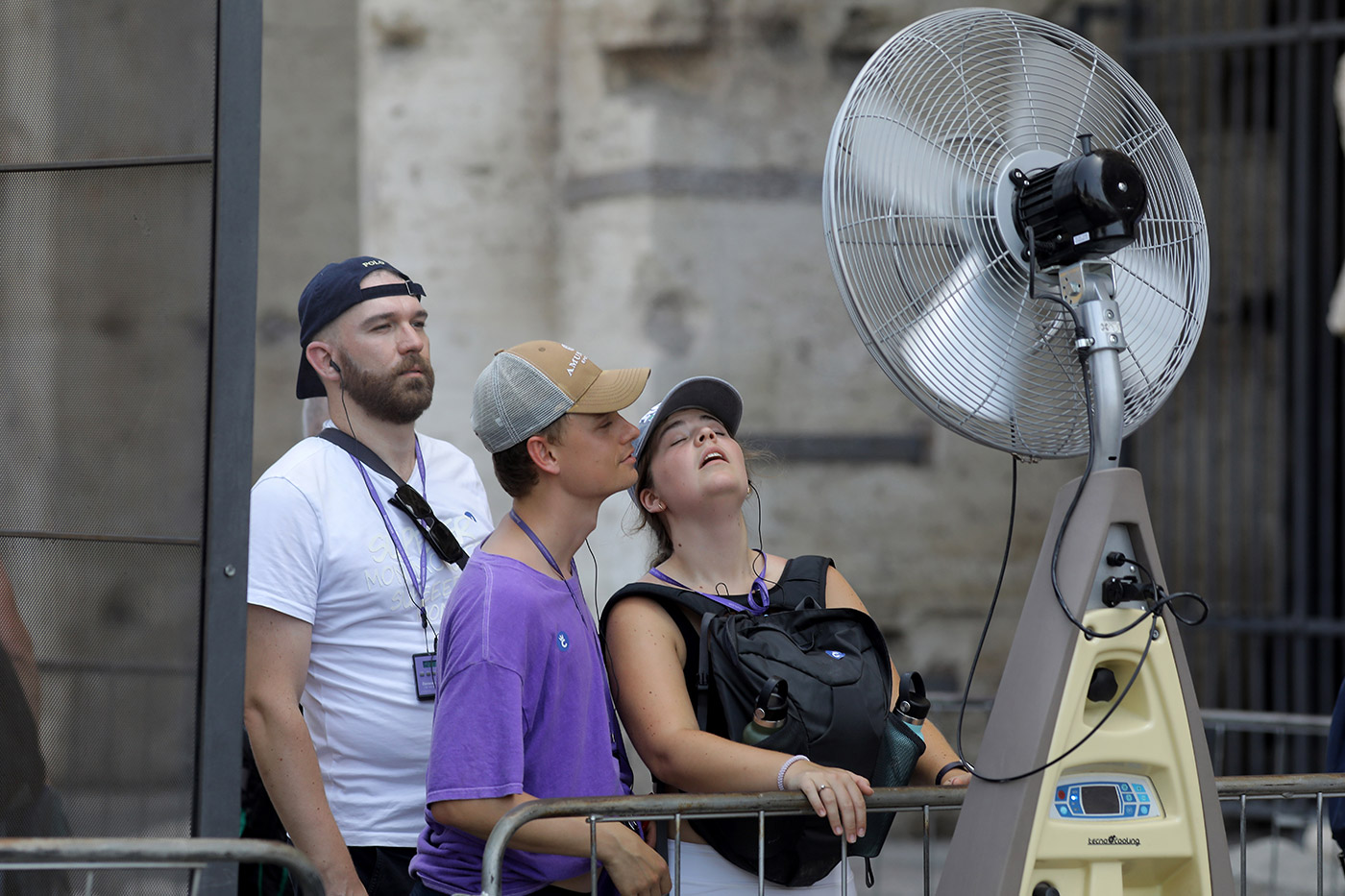 ​​Tourists cool off with a fan spraying nebulised water during a hot day in Rome - 18 July 2023