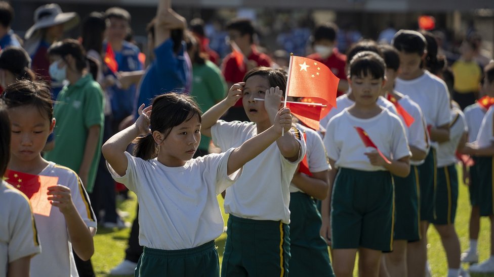 Students waving China National Flag on October 1, 2023 in Hong Kong, China. Today marks China's National Day (Photo by Vernon Yuen/NurPhoto via Getty Images)