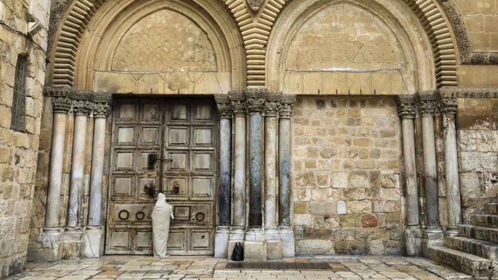 Una cristiana en las puertas cerradas de la iglesia del Santo Sepulcro en Jerusalén.
