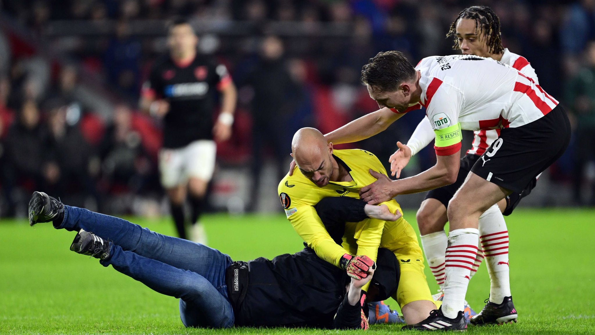 PSV Eindhoven 2-0 Sevilla: Visiting goalkeeper Marko Dmitrovic is attacked on the pitch by...