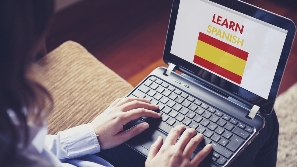 Una persona frente a una computadora para aprender español.