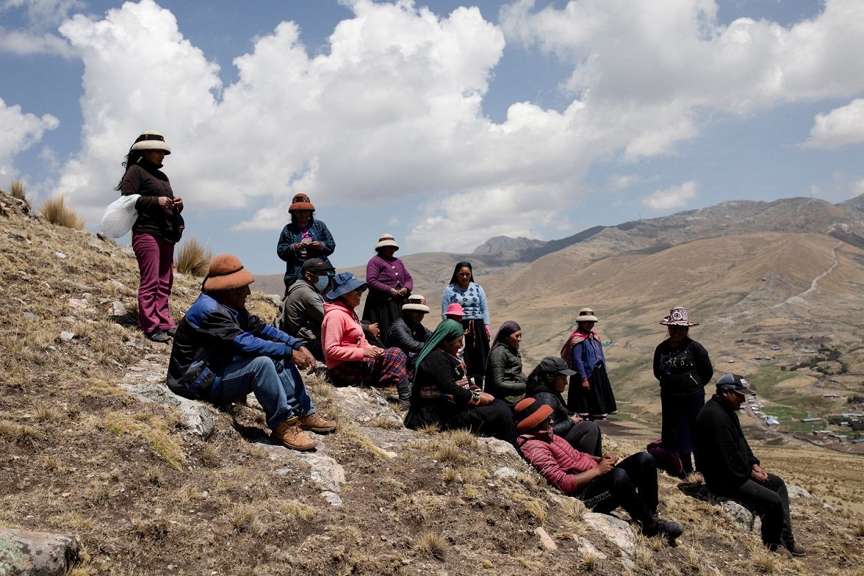 秘魯民眾坐在拉斯邦巴斯礦山附近的山上。當地居民稱採礦活動對農作物產量產生了負面影響，並導致牲畜死亡。