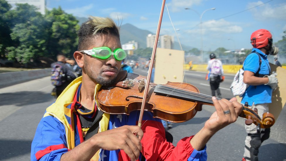 покрытый пылью мужчина в очках для плавания, играющий на скрипке