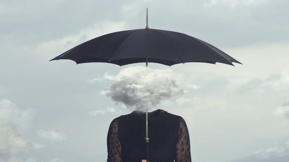 Concept image: A woman with a cloud for a head, holding an umbrella