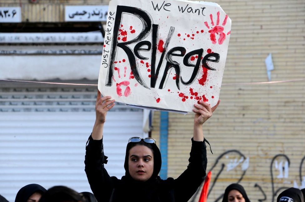 Иранский протест держит знак, призывающий к мести США