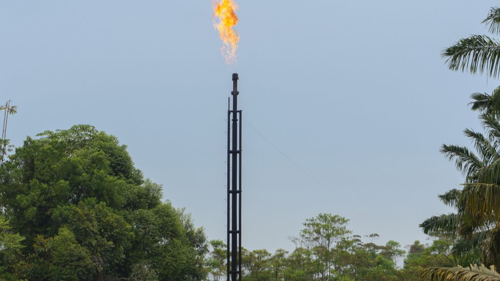 Vista frontal de la torre de un pozo de gas natural en producción quema gas