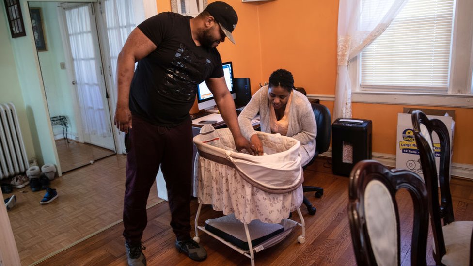 Una pareja cuida de un recién nacido en Nueva York