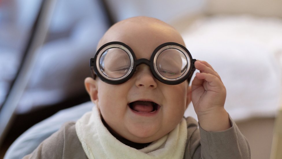 Un bebé con unos lentes de juguete.