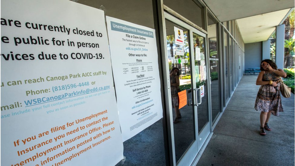 Женщина у закрытого офиса Департамента занятости штата Калифорния из-за коронавируса.