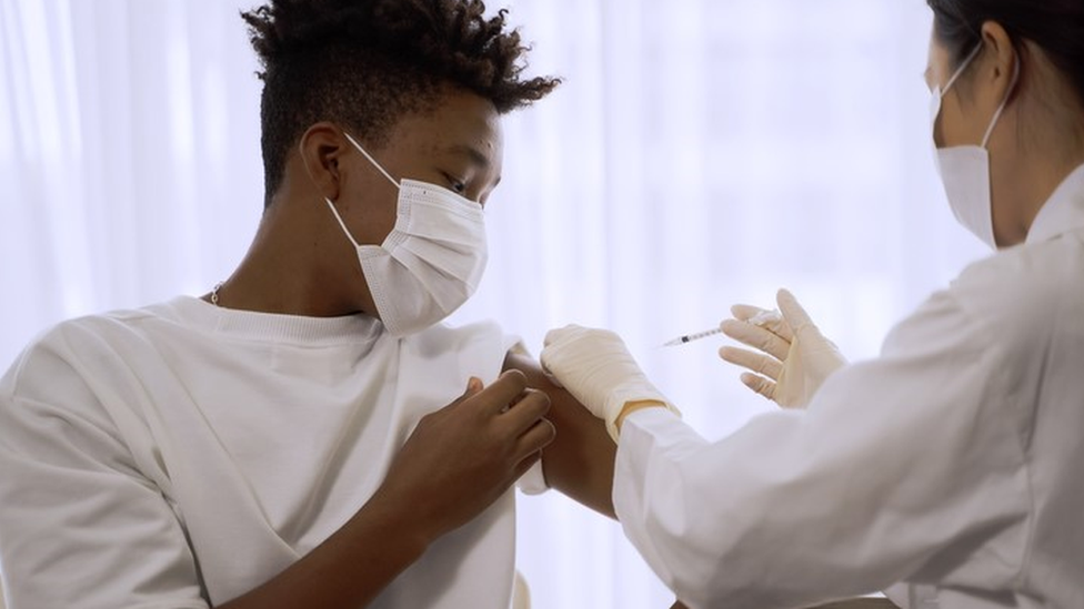 Adolescente toma vacina no braço