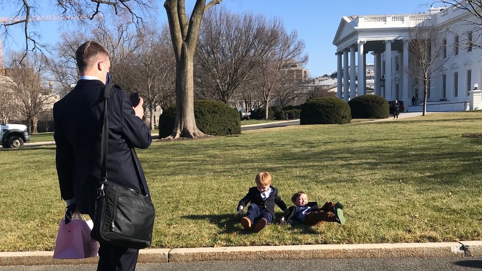 Seorang anak mengambil foto anak-anak di halaman Gedung Putih.