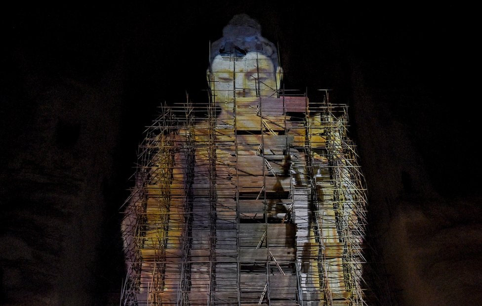 A close-up shot of the Salsal Buddha, projected in the void where it used to stand